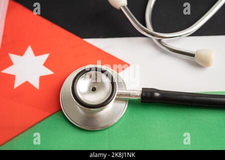 Schwarzes Stethoskop auf jordanischer Flagge, Geschäfts- und Finanzkonzept. Stockfoto