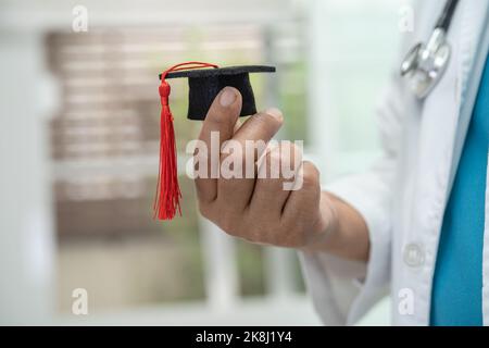 Asiatische Arzt Studie lernen mit Abschluss GAP Hut in Krankenhausstation, clever hell Genie Bildung Medizin Konzept. Stockfoto