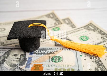 Graduation GAP hat auf US-Dollar-Banknoten Geld, Bildung Studiengebühr Lernen Lehre Konzept. Stockfoto