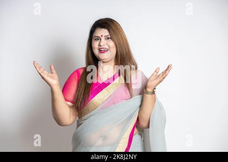 Porträt von glücklich fröhlich übergewichtig reifen schönen indischen Frau trägt Saree mit offenen Armen und Händen erhobene Geste isoliert auf weißem Hintergrund Stockfoto