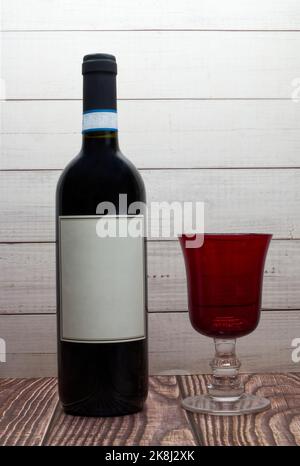 Flasche Rotwein mit leerem Etikett und rotem Glas Stockfoto