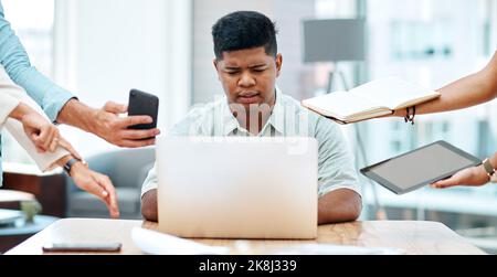 HES fällt hinter allem zurück, was getan werden muss. Ein junger Geschäftsmann, der gestresst in einem anspruchsvollen Büroumfeld aussieht. Stockfoto