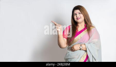 Glückliche indische Frau trägt Saree zeigt leeren Raum für Ihre Förderung isoliert auf weißem Hintergrund, Übergewicht oder Plus-Größe weibliche Modell zeigt fing Stockfoto