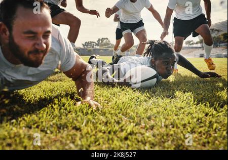 Hes einfach bis zur Aufgabe. Eine Gruppe von schönen jungen Rugby-Spieler, die zusammen auf dem Feld trainieren. Stockfoto