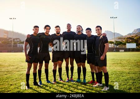 Wir teilen eine gemeinsame Liebe zum Sport. Ganzkörperportrait einer vielfältigen Gruppe von Sportlern, die vor dem Rugby-Spiel während des Tages zusammenstehen. Stockfoto