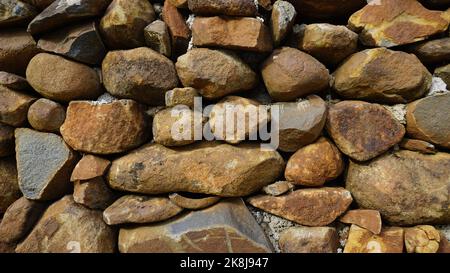 Schönes Hintergrundbild Bild einer Wand aus runden Stein roten Farbe Felsen. Abstrakte Struktur im Landscape-Design Stockfoto