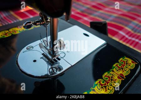 februar 12. 2022, Dehradun City India. Hände Bedienungsanleitung Nähmaschine Nadelstange mit Gewinde. Stockfoto