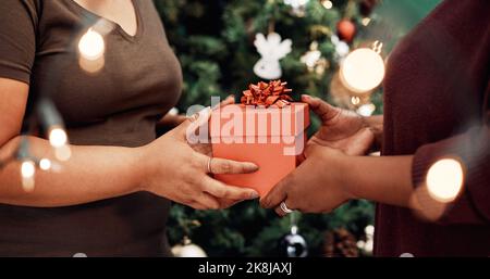 Mit guten Freunden haben Sie das größte Geschenk von allen. Zwei unkenntlich Frauen tauschen Geschenke während Weihnachten zu Hause. Stockfoto