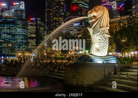 Der Singapore Merlion, aufgenommen in der Nacht mit dem Central Business District im Hintergrund Stockfoto