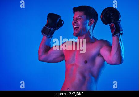 Die Gewohnheit des Beharrens ist die Gewohnheit des Sieges. Blau gefilterte Aufnahme eines Sportlers, der Boxhandschuhe trägt, während er im Studio posiert. Stockfoto