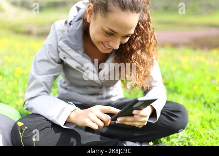 Glücklicher Wanderer, der im Berg sein Smartphone überprüft Stockfoto