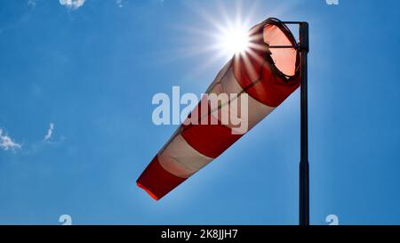 Windsack. Windsock-Flagge. Windrichtungsanzeige. Windstärke. Windsack vor blauem Himmel. Stockfoto