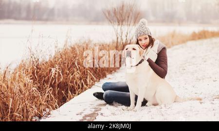 Mädchen streichelte Hund im Winter Park Stockfoto