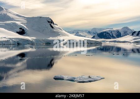 Stillwasser des Paradieshafens (Bucht) mit lemaire Insel und munoz Point (l und c) und chilenischer gonzalez videla antarktisbasis (r) am Wasserboat Point Stockfoto