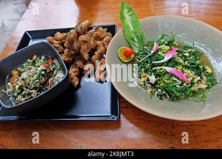 Geschmorter und frittierter Fisch mit Kräutersauce, Malindjoblätter mit Eiern anbraten Stockfoto