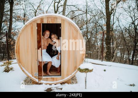 Seniorenpaar genießen gemeinsam Zeit in Holzsauna, Entspannung, Spa und gesundes Lebenskonzept. Stockfoto