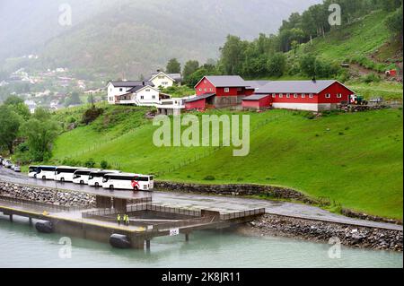 Skjolden, Sognefjord, Norwegen - 28.. Juni 2022:Arbeiter und Coaches warten auf die Andockung des Kreuzfahrtschiffs Stockfoto