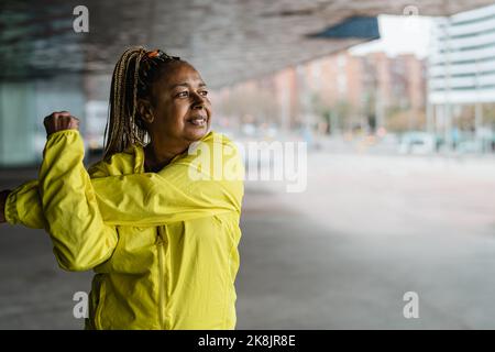 Ältere afrikanische Frau macht Aufwärmübungen im Freien - Ältere Sportliche Menschen Lifestyle-Konzept Stockfoto