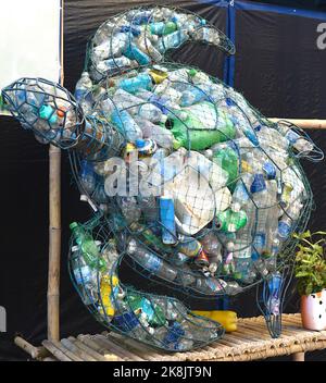 Schildkrötenform Mülltonne voller Plastikflaschen und Dosen als Propaganda für Ökologie Stockfoto