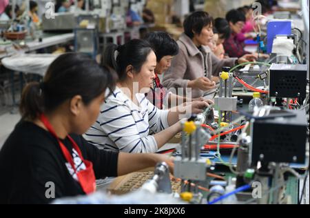 FUYANG, CHINA - 24. OKTOBER 2022 - Arbeiter arbeiten an der Lautsprecherproduktionslinie von Linquan Wuyang Electronics Co LTD in der Stadt Fuyang, Provinz Anhui, Stockfoto