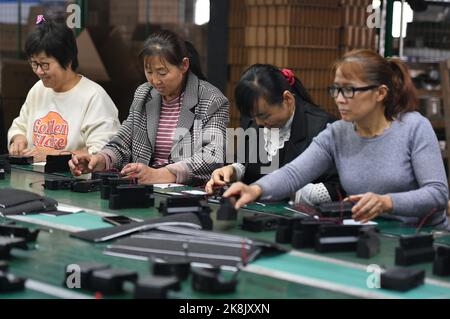 FUYANG, CHINA - 24. OKTOBER 2022 - Arbeiter arbeiten an der Lautsprecherproduktionslinie von Linquan Wuyang Electronics Co LTD in der Stadt Fuyang, Provinz Anhui, Stockfoto