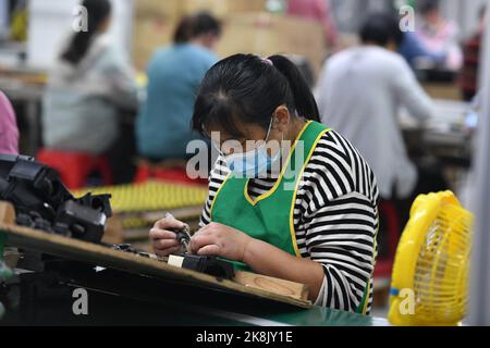 FUYANG, CHINA - 24. OKTOBER 2022 - Arbeiter arbeiten an der Lautsprecherproduktionslinie von Linquan Wuyang Electronics Co LTD in der Stadt Fuyang, Provinz Anhui, Stockfoto