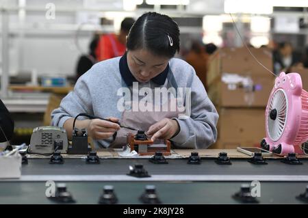 FUYANG, CHINA - 24. OKTOBER 2022 - Arbeiter arbeiten an der Lautsprecherproduktionslinie von Linquan Wuyang Electronics Co LTD in der Stadt Fuyang, Provinz Anhui, Stockfoto