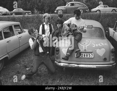 Karlskoga, August 1963, Schweden. 30 - 40.000 junge Menschen, darunter einige Rager, nehmen Karlskoga, um sich das Kanonenrennen (Autorennen) anzusehen. Die Polizei trifft sich stark, um in der Stadt Ruhe zu bewahren. Jugendliche versammelten sich um ein Auto. Spielt Gitarre Foto: Ivar Aaserud / Strom / NTB Stockfoto