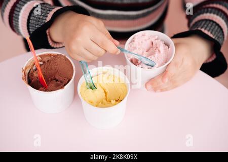 Kinder essen Eis in einem Café. Set von Schüsseln mit verschiedenen Eiscreme mit verschiedenen Geschmacksrichtungen und frischen Zutaten Stockfoto