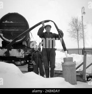 Hedmark im Winter 1948. Wasserknappheit in Ostnorwegen nach der Dürre im Sommer 1947. Die Betriebe müssen Wasser in den Flüssen holen oder Wasser aus den Molkereien fließen lassen. Hier ist ein Landwirt, der Wasser aus einem Tankwagen auf den Milcheimer klopft. Dieses kostbare Wasser aus der Molkerei ist für den Haushalt bestimmt. Foto: Børretzen / Aktuell / NTB Stockfoto