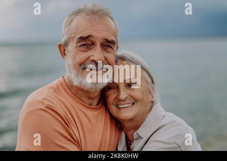 Porträt eines verliebten älteren Paares, das im Freien in der Natur steht und umarmt. Stockfoto