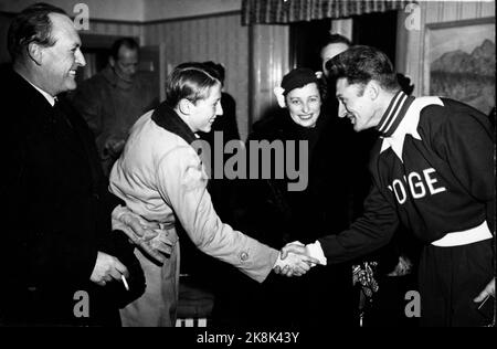 19520219 Oslo: Olympische Spiele, Winterolympiade, Schlittschuhlauf, schnelles Rennen, 10.000 Meter: Hjalmar Andersen 'Hjallis' gewann die 10.000 Meter, und hier wird er von Prinz Harald gratuliert. TV. Kronprinz Olav und in der Mitte Prinzessin Ragnhild. König Olav mit Zigarette in der Hand. Foto ntb Stockfoto