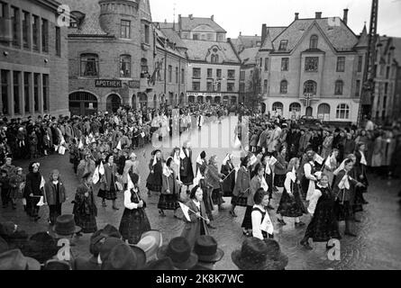 Ålesund 19480413: 100.-jähriges Jubiläum der Stadt Ålesund. Das Jubiläum wurde in vielerlei Hinsicht gefeiert, unter anderem mit einem großen Menschen- und Kinderzug durch die Stadt. Die strömenden Regenfälle dämpften die Partyatmosphäre nicht. Hier pariert der Zug über den Apothekenplatz. Die alte Jugendstilapotheke im Hintergrund. Foto: Current / NTB Stockfoto