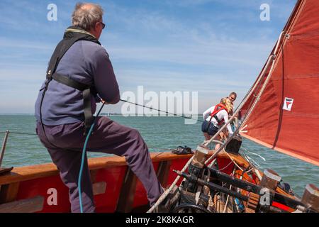 Die Crew arbeitet an Bord des traditionellen Gaffelschneiders „Jolie Brise“ in Solent, Hampshire, Großbritannien, am Bugsprit Stockfoto