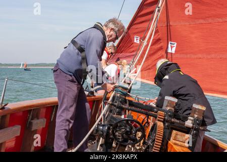 Die Crew arbeitet an Bord des traditionellen Gaffelschneiders „Jolie Brise“ in Solent, Hampshire, Großbritannien Stockfoto