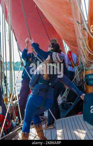 Die Crew arbeitet an Bord des traditionellen Gaffelschneiders „Jolie Brise“ in Solent, Hampshire, Großbritannien Stockfoto