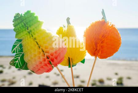 Farbenfrohe Cocktaildekorationen auf dem Hintergrund des blauen Himmels und des Meeres, Sandstrand am sonnigen Sommertag. Konzept Zeichen Symbol für Urlaub Tourismus Reise Entspannung Urlaub Erholung Feier Reisen Tropen Stockfoto