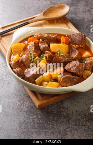 Irischer Eintopf aus Irland ist ein Eintopf aus Irland, der traditionell mit Wurzelgemüse und Fleisch aus der Nähe im Topf auf dem Tisch zubereitet wird. Vertikal Stockfoto