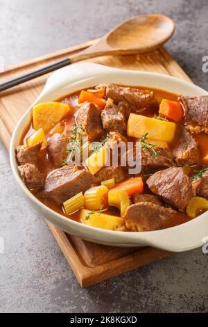 Irish Beef and Guinness Eintopf mit saisonalem Gemüse in der Nähe in den Topf auf dem Tisch. Vertikal Stockfoto