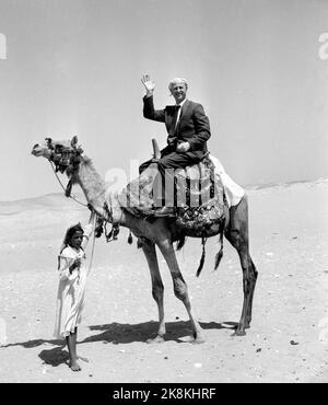 Kairo, Ägypten 19590515 Fliegender Teppich mit Jet. Urbound und Jet Age trafen sich in Ägypten, als SAS am 15. Und 16. Mai seine caravelle-Route zwischen Skandianvia und Kairo eröffnete. Zwischen der Pyramide und dem Jet ist eine riesige Schnalle in der Zeit und Entwicklung. Mit seinen neuen, schnellen Karavellen trägt SAS dazu bei, Menschen und Kontinente enger miteinander zu verbinden. Reiten in Kamel ist eine große Touristenattraktion in Ägypten und die Teilnehmer an der Einweihungsreise mit den Caralvellen mussten es versuchen. Hier ist der Herausgeber des aktuellen Asmund Rørslett auf dem Kamelrücken. Foto: Asmund Rørslett / Current / NTB Stockfoto