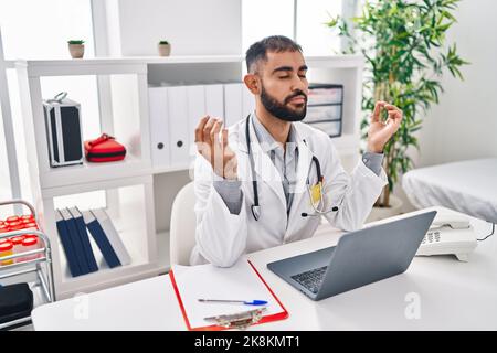 Junger hispanischer Arzt, der in der Klinik Yoga-Übungen macht Stockfoto