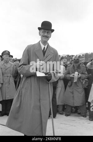 Svinesund 19460615. Die Svinesundbrücke in Halden zwischen Norwegen und Schweden wird von König Haakon und Kronprinz Gustav Adolf inmitten der 420 Meter langen Brücke eröffnet. König Haakon bereit mit der Schere, mit der er die Schnur schneiden wird. Mantel, Hut und Stock. Foto: NTB Archive / NTB Stockfoto