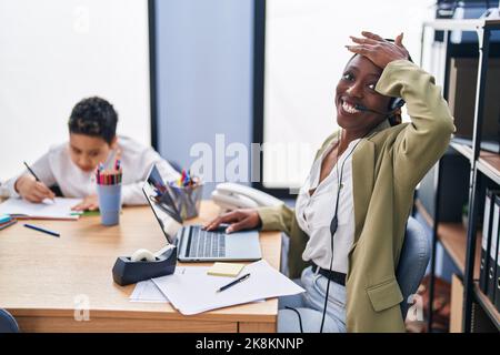 Die junge Mutter, die das Headset eines Callcenters trägt, ist gestresst und frustriert, mit der Hand auf dem Kopf, überrascht und wütend Stockfoto