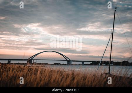 Die Fehmarn Sound Bridge in Deutschland gegen bewölkten Himmel bei Sonnenuntergang Stockfoto