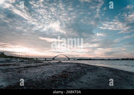 Die Fehmarn Sound Bridge in Deutschland gegen bewölkten Himmel bei Sonnenuntergang Stockfoto