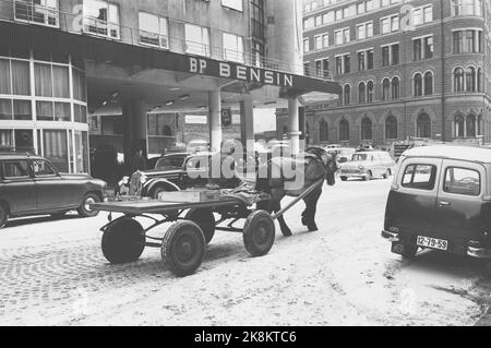 Oslo 19640314. Das Pferd Petter ist das einzige Arbeitslicht im Zentrum der Hauptstadt. Es migriert täglich zu Kunden im Zentrum von Oslo. Er macht eine Pause im Hinterhof, den Ivar Aasen zu seiner Zeit gelebt hat. Petters Fahrer heißt Simen Byfuglien 58 Jahre und kommt aus Etnedal in Valdres, der den Transport mit Pferd und Wagen betreibt. BP-Tankstelle. Foto: Sverre A. Børretzen Current / NTB Stockfoto