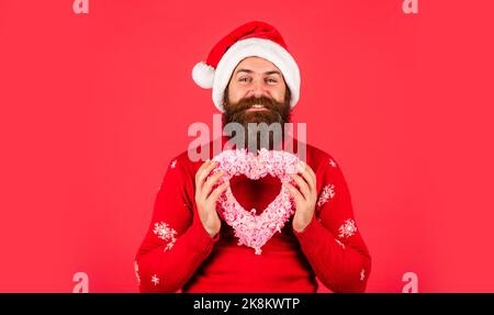 Schöner Mann Liebe Winterurlaub roten Hintergrund. Frohe weihnachten und Frohes neues Jahr. Lass mich dein Herz schmelzen. Begrüßen Sie Weihnachten in Ihrem Herzen. Mann Stockfoto