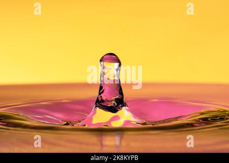 Wassertropfen Spritzer isoliert auf gelbem Hintergrund. Stockfoto