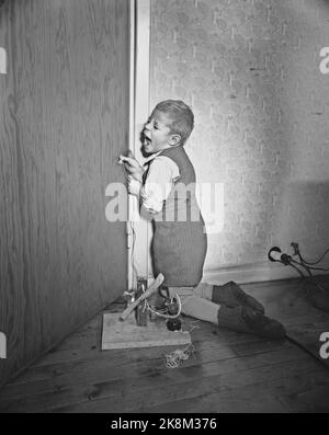 Oslo 19540109 Sie sind in Gefahr, wo Sie hingehen das Zuhause ist ein gefährlicheres Arbeitsumfeld, als viele Hausfrauen wissen. Hausunfälle, Illustration Foto. Der Junge umarmt seine Finger in die Tür und es tut weh. Foto: Sverre A. Børretzen / Aktuell / NTB Stockfoto