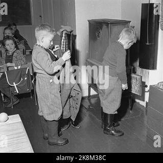 Aurskog 11 February 1956 'Diese Kinder haben 3 Meilen Schulstraße' die jungen Kinder Kjell aus Nybak, Hallvard aus Sinkerud und Marit aus Stenshaugen müssen 6 km allein durch den nächtlichen Schwarzwald laufen, bevor sie den Schulbus in Bekkesaga erreichen. Sie müssen um 5 Uhr aufstehen, um den Bus zu erreichen, der zur Haneborg-Schule in Aurskog fährt. Nach zweieinhalb Stunden Schulzeit ist es gut, in die Hitze zu kommen und Socken und Fäustlinge zum Trocknen aufhängen zu lassen. Foto; Sverre A. Børretzen / Aktuell / NTB Stockfoto